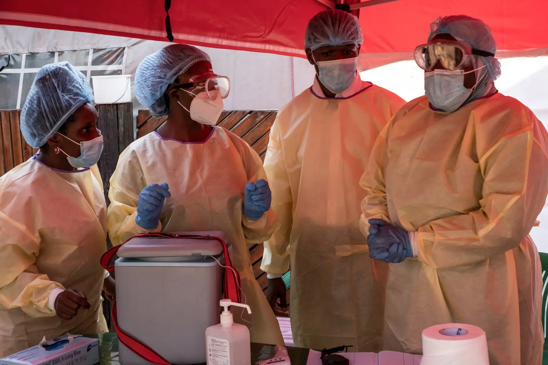 Profissionais de saúde usam roupas médicas de proteção antes de manusear frascos de vacina durante o lançamento de uma campanha experimental de vacinação contra o Ebola no Hospital de Referência Mulago.