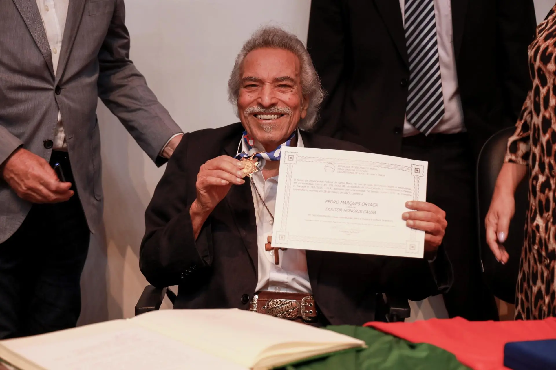 foto do cantor Pedro Ortaça recebendo título de doutor Honoris Causa da Universidade Federal de Santa Maria (UFSM).