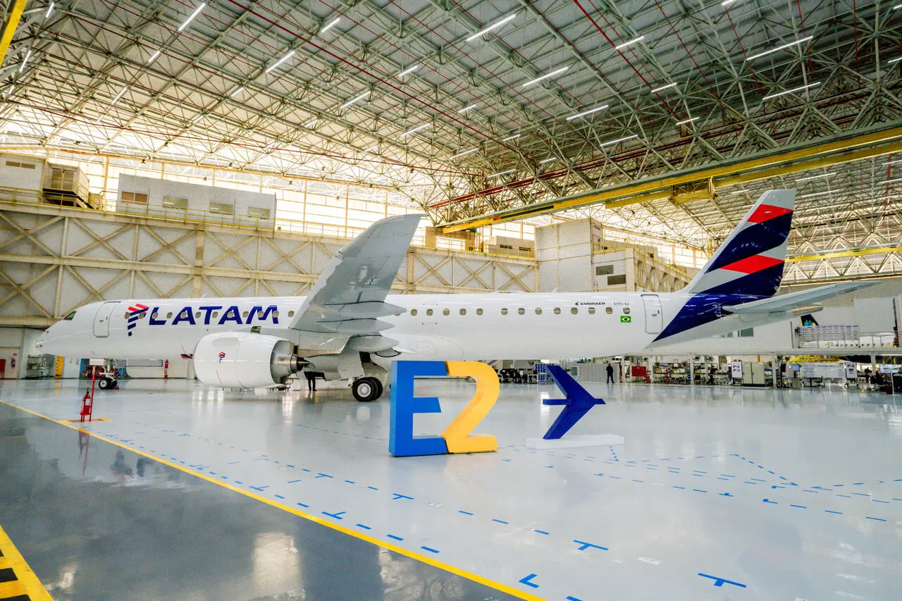 imagem mostra E195-E2 da latam no hangar da embraer.