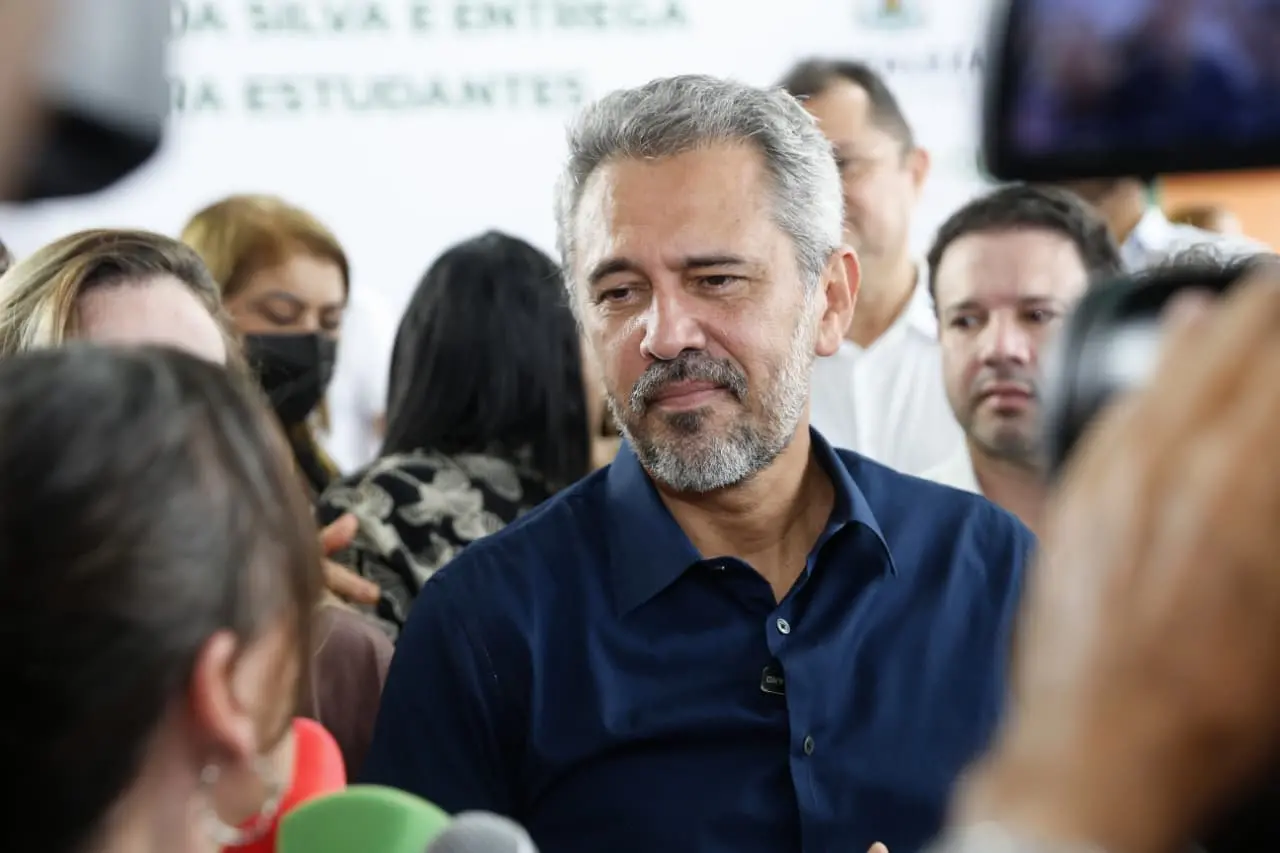 Governador Elmano de Freitas durante coletiva de imprensa. Ele é um homem de meia idade de barba e cabelo grisalhos e está com camisa social azul.