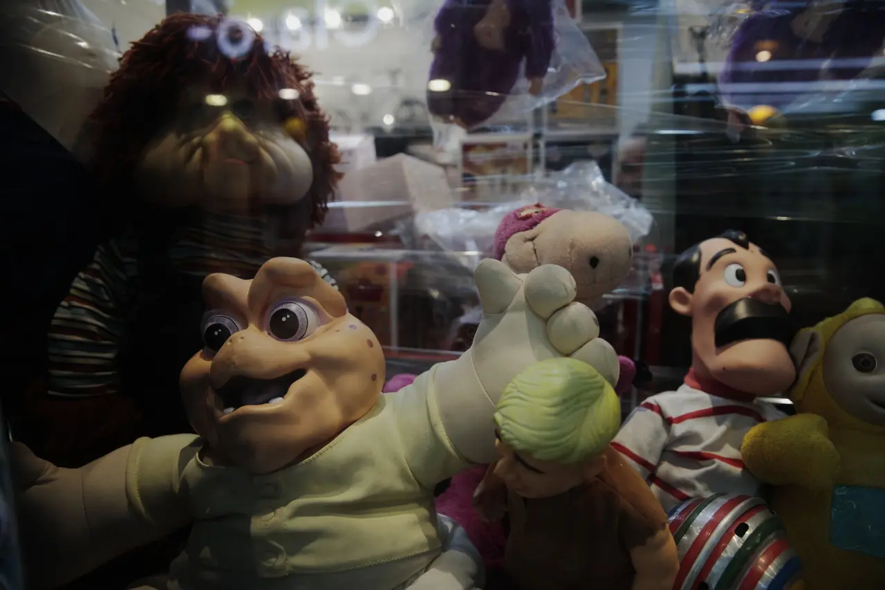 Vitrine com destaque para o boneco de pano Baby da Família Dinossauros e Fofão.