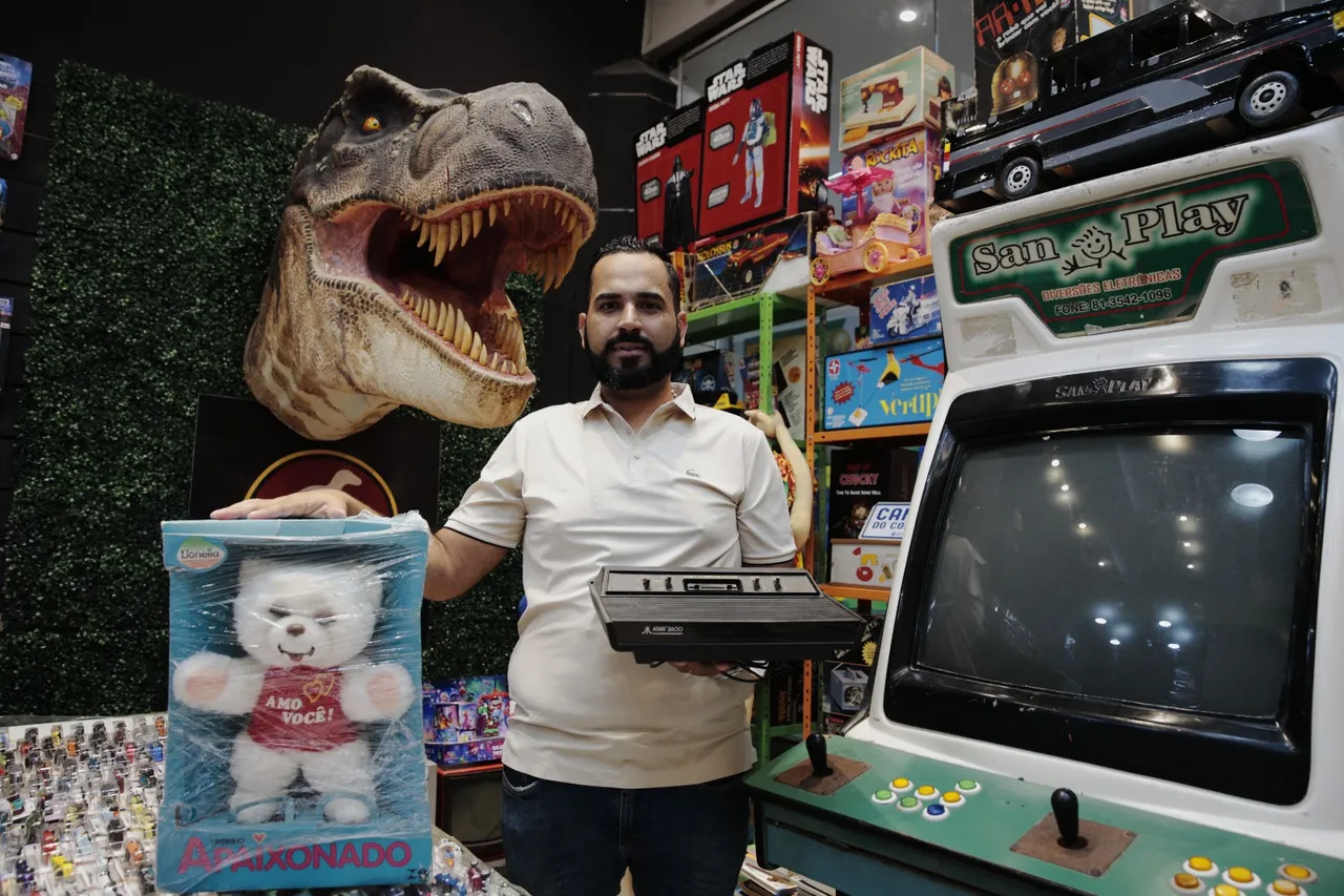 Videogames, como o Atari 2600, que chegou no Brasil em 1983, e o urso de pelúcia Amo Você da Lionella, ainda em caixa, são destaque de procura na loja.