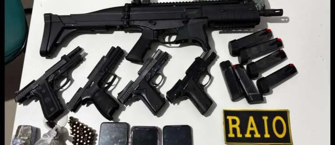 Foto que contém armas de fogo, munição e celulares apreendidos pela polícia.