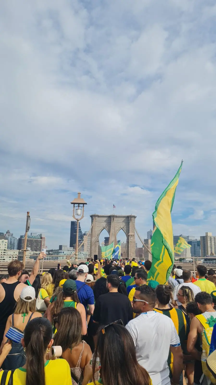 Imagem em plano aberto de uma travessia da Ponte do Brooklyn, em Nova York, com a presença de diversos torcedores da Seleção Brasileira