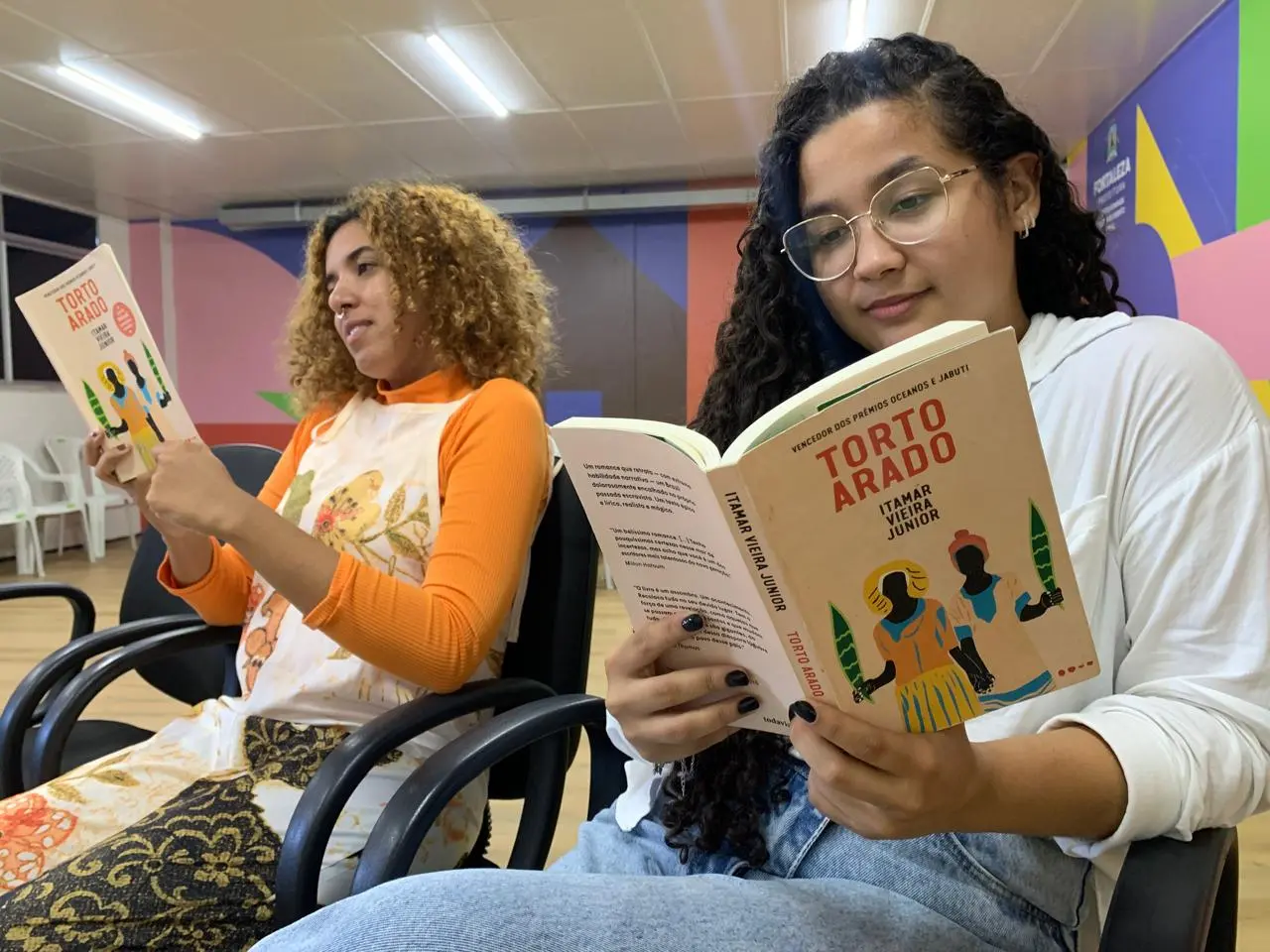 Uma mulher de óculos lê o livro 