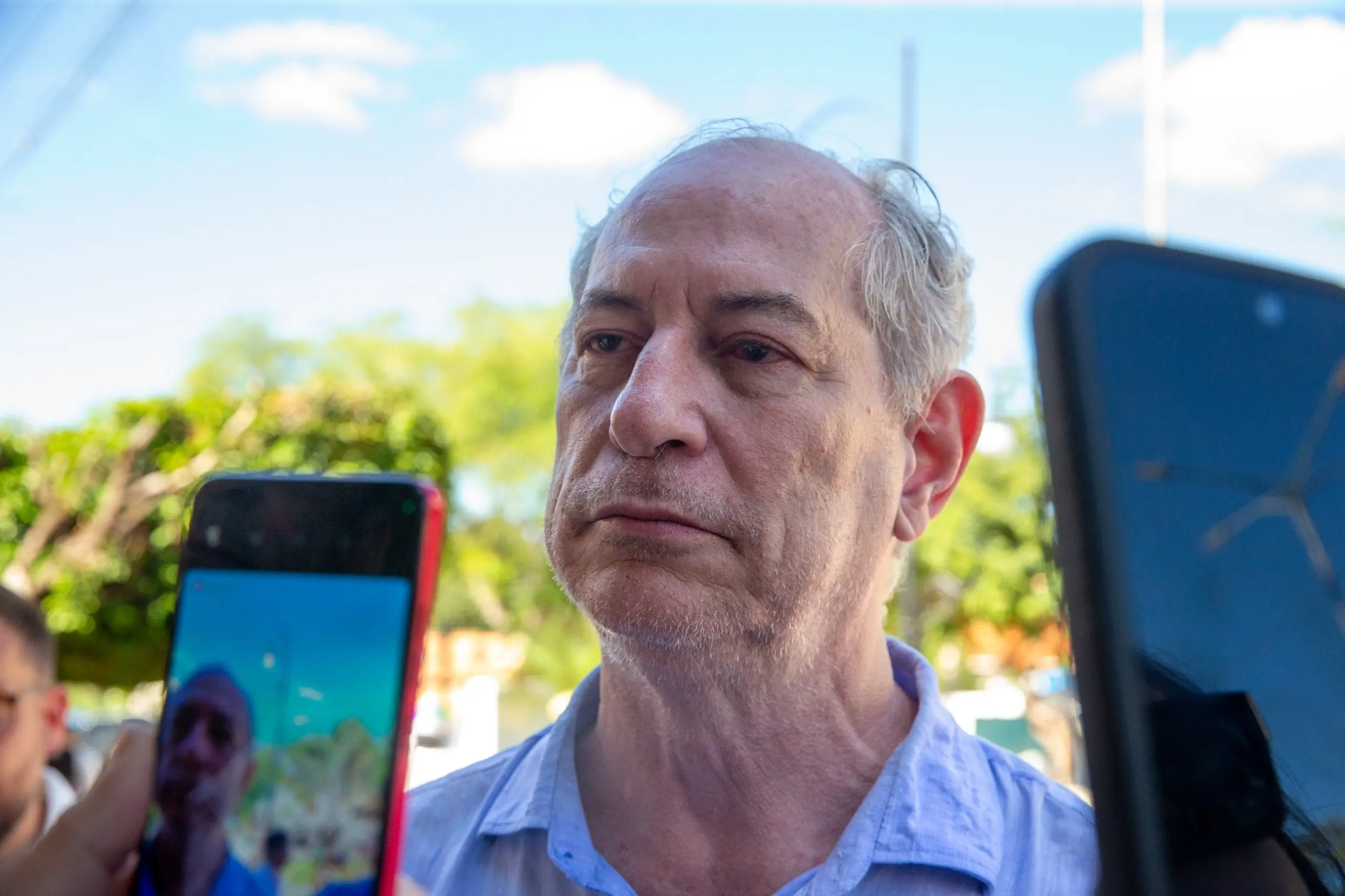 Ciro Gomes ouvindo pergunta de repórter durante entrevista. Ele é filmado por um celular.
