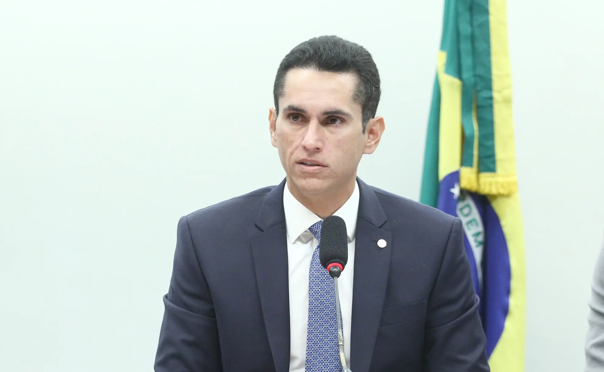 Domingos Neto em mesa da Câmara dos Deputados. Ele fala ao microfone.