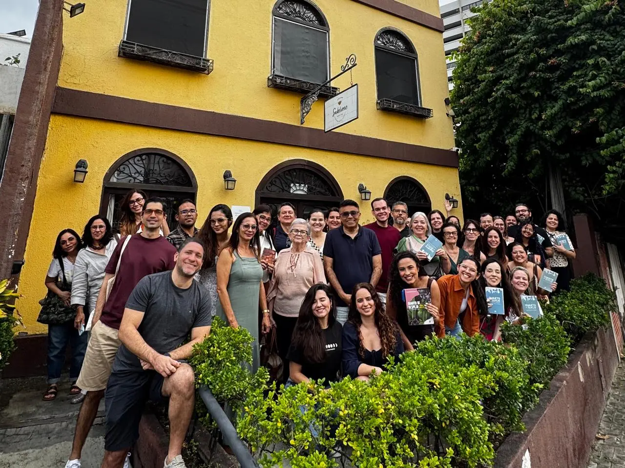 pessoas posam para foto em frente a um café