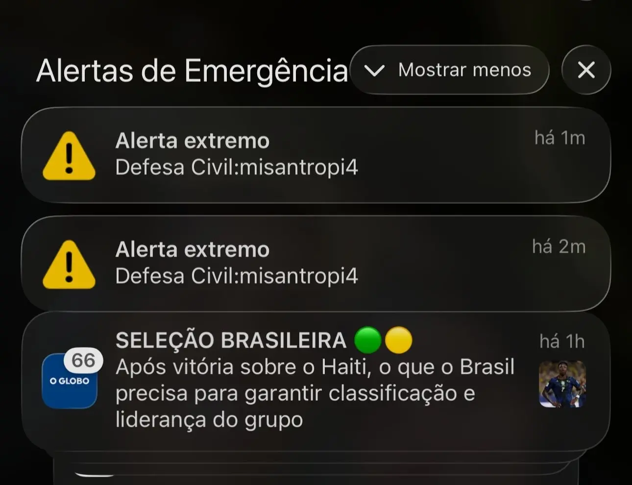 Captura de tela com alertas de emergência no topo, mostrando duas mensagens de “Alerta extremo” da Defesa Civil e, abaixo, uma postagem da “Seleção Brasileira” após vitória sobre o Haiti, com sinalizações de tempo e ícones de emojis