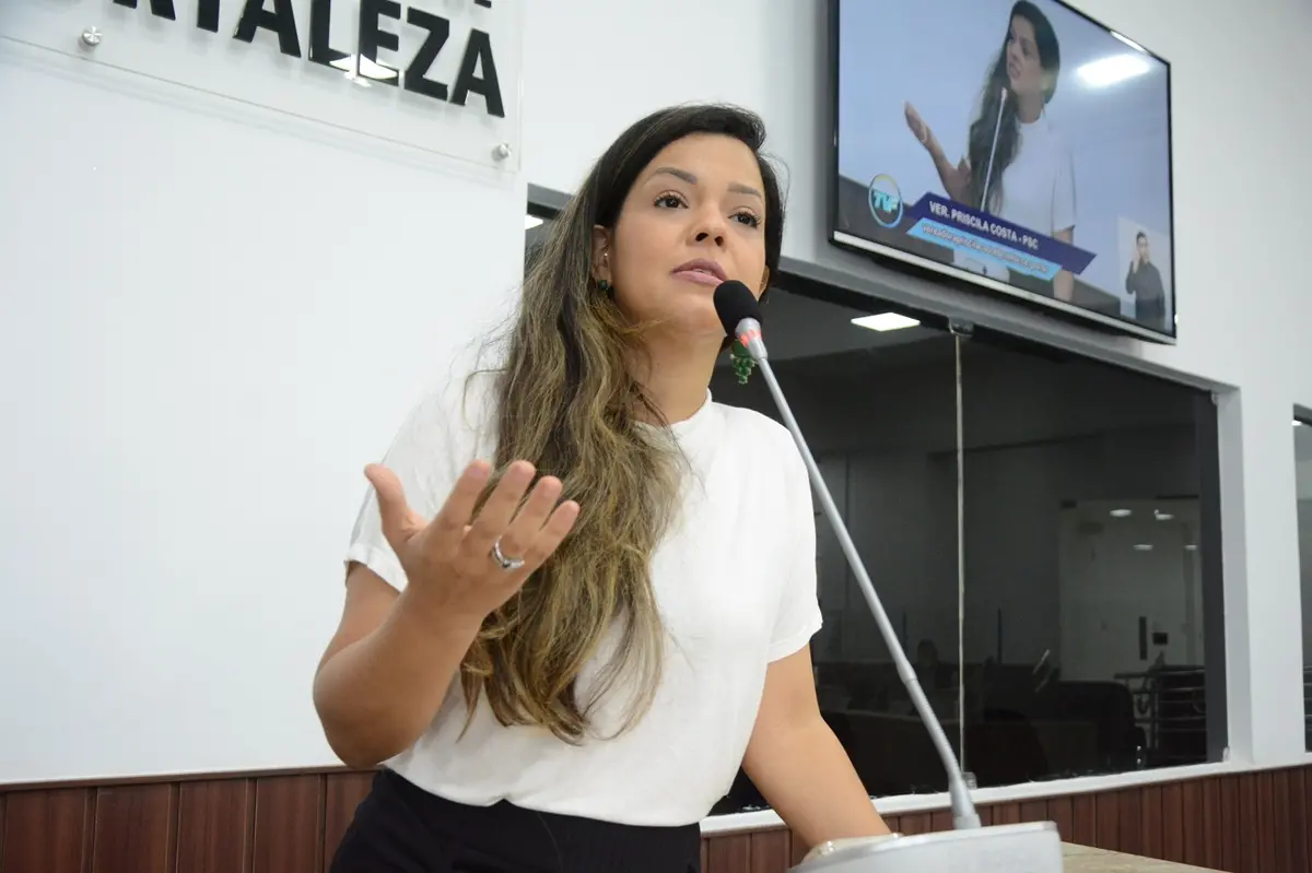 Vereadora Priscila Costa de camiseta branca discursando na tribuna da Câmara Municipal de Fortaleza.