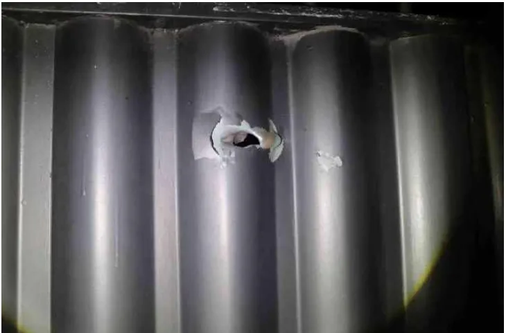Marca de bala no portão de uma residência, no local do crime.
