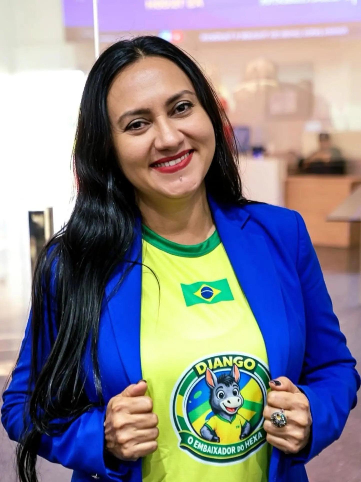 Vereadora Jacqueline Gouvea sorri para a câmera. Ela veste roupas com as cores da seleção.