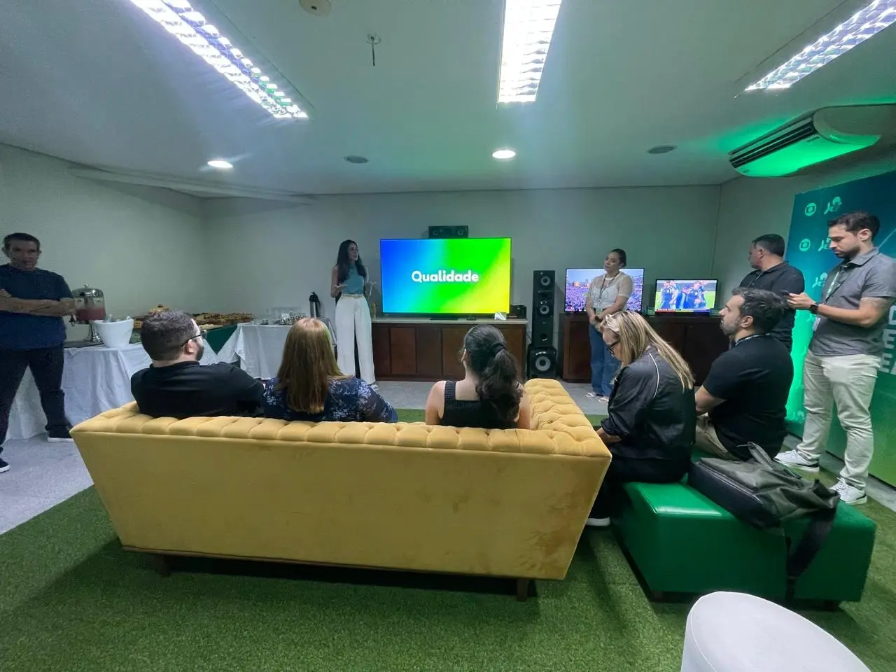 Pessoas em uma sala assistem a uma demonstração da TV 3.0