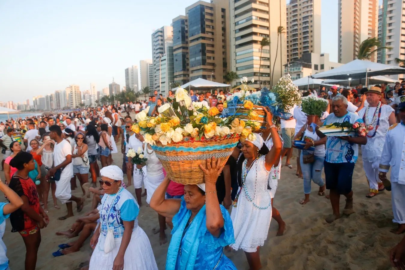 Durante a celebração, filhos de Iemanjá e simpatizantes levam ao mar champanhe, flores e outros presentes; oferendas são biodegradáveis para evitar danos ambientais.