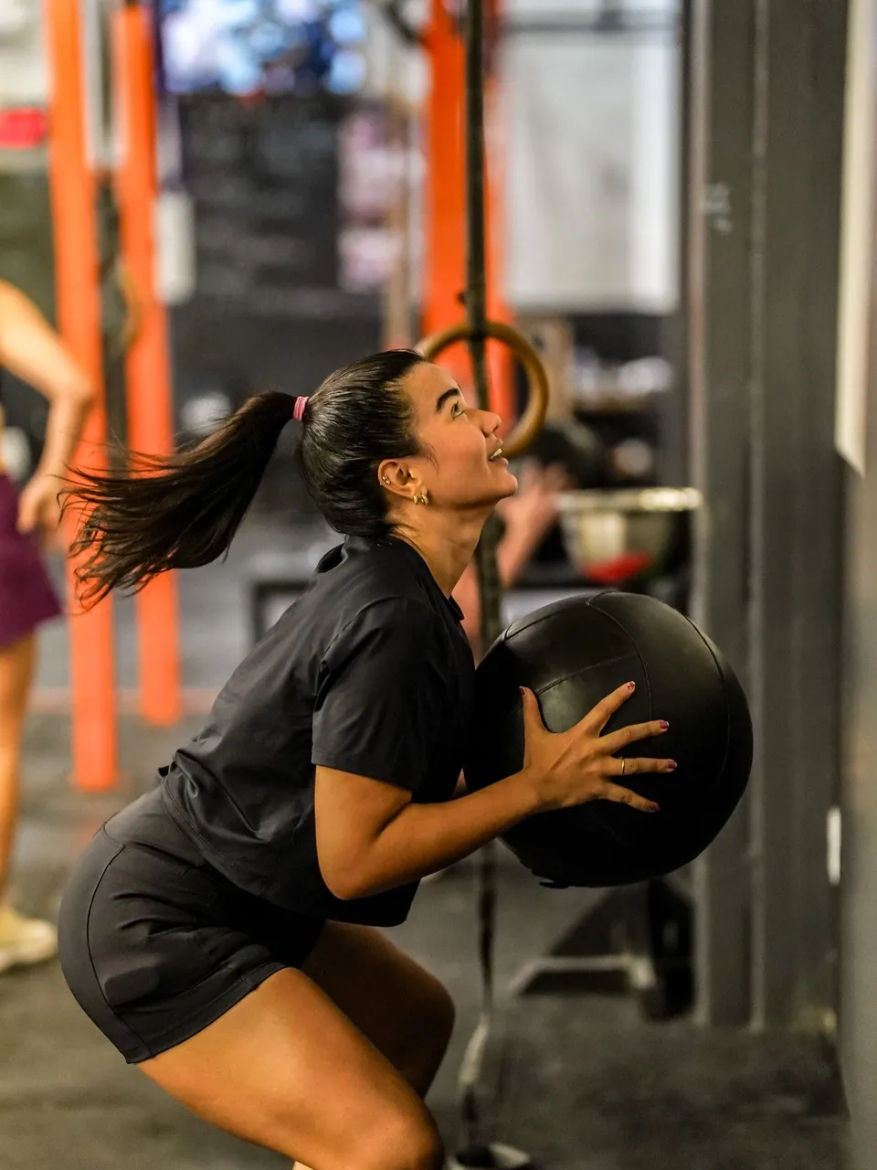 Treinamento de Hyrox de  Wall Balls, agachamento arremessando bola na parede