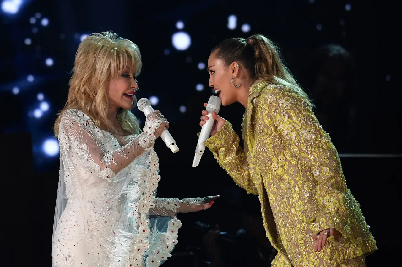 Imagem da notícia Dolly Parton era madrinha de Miley Cyrus: ‘Como uma mãe para mim’