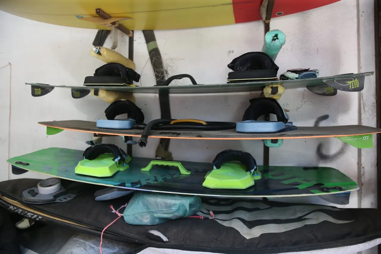 Pranchas de kitesurf em estande na parede.