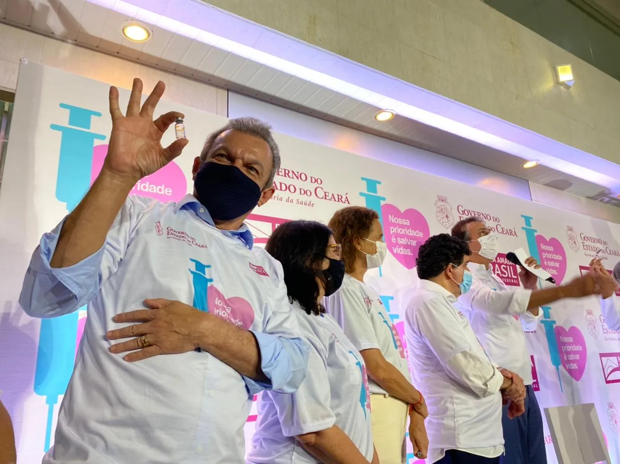 O prefeito de Fortaleza, Sarto Nogueira, segura o segundo frasco da CoronaVac aplicada no Ceará