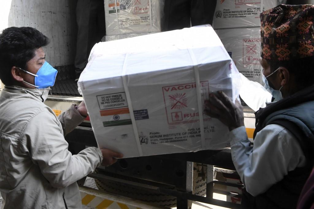 Trabalhadores descarregam uma caixa contendo a vacina contra a Covid-19 fabricada na Índia