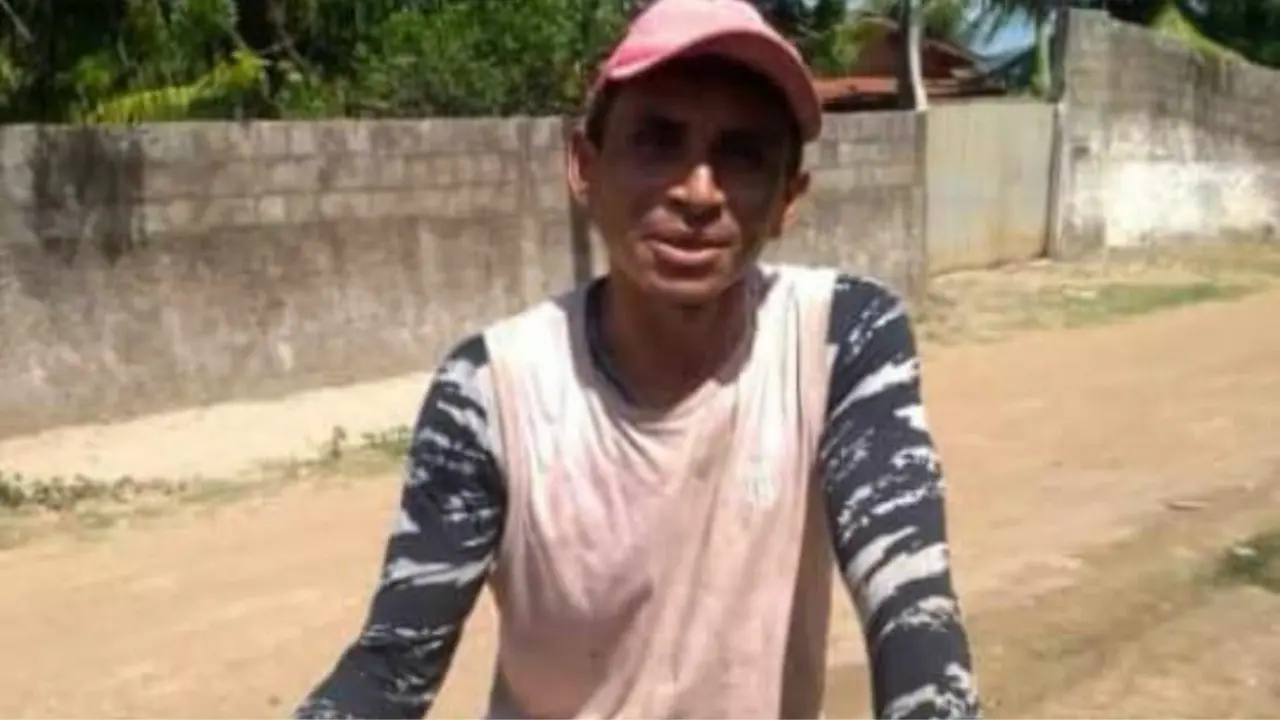 Fotografia de um homem vestindo uma regata vermelha desbotada e, por baixo, uma blusa de manga longa nas cores branco e preto