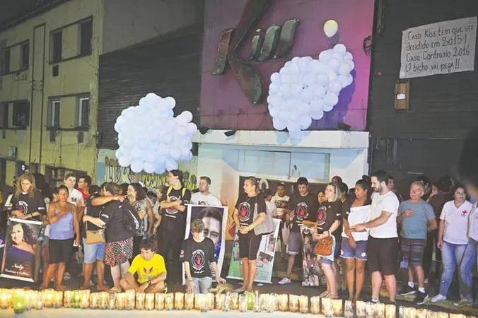 Esta imagem mostra familiares das vítimas mortas no boate homenageando a tragédia em frente ao local
