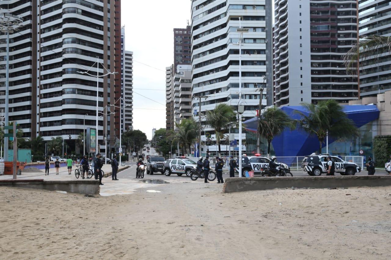 Agentes da Polícia Militar observam a movimentação de pedestres no calçadão e na faixa de areia da Beira Mar