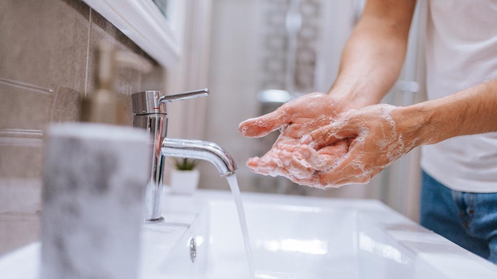 Homem lava as mãos em pia de banheiro