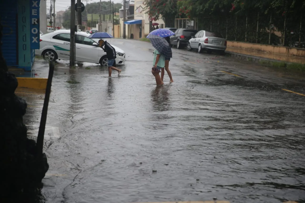 Pedestres também sofreram com ruas inundadas durante a chuva forte desta sexta-feira.