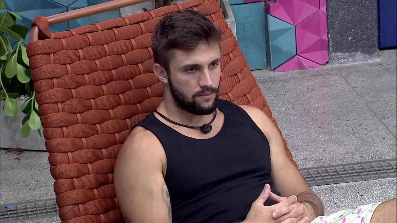 Foto de Arthur, que foi eliminado do BBB 21, sentado em uma cadeira