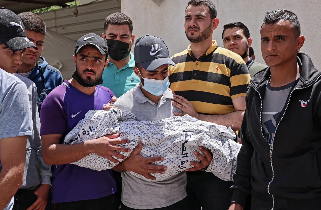 Pai segura filho morto em ataque, na Faixa de Gaza