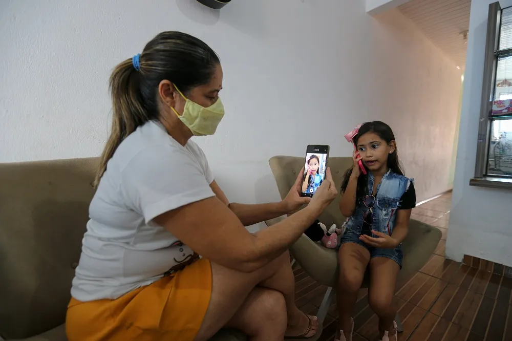 Com o auxílio da mãe, a autônoma Sandra Almeida, Maria Júlya grava vídeos nos quais simula pequenas cenas do cotidiano
