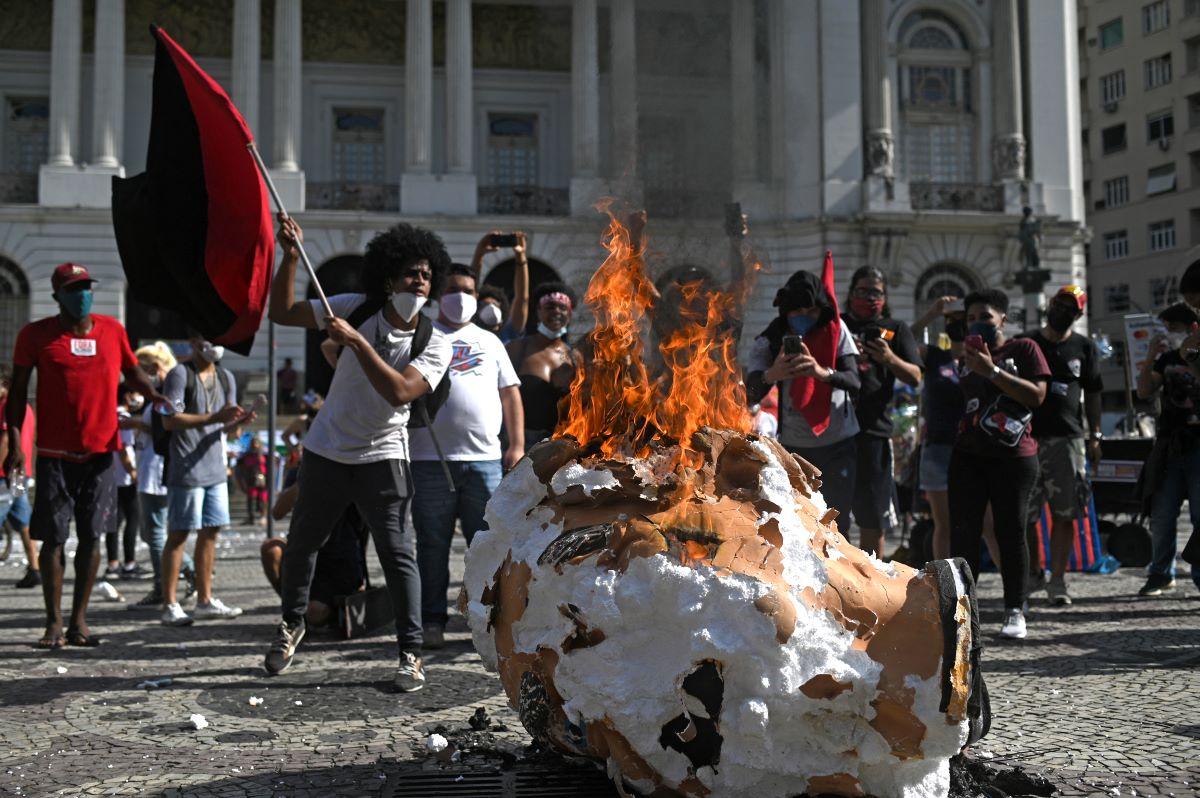 manifestante queima boneco com o rosto de bolsonaro em protesto no rio de janeiro