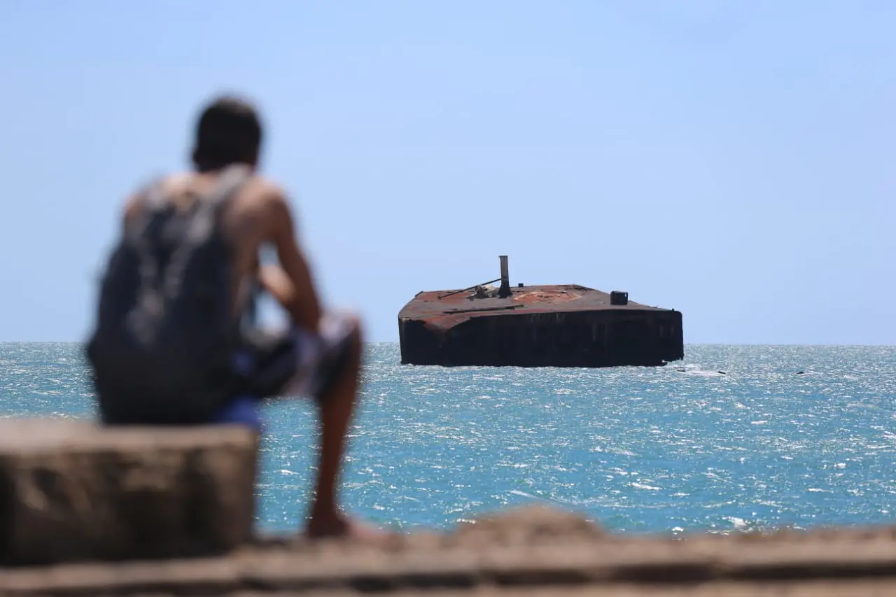 jovem observa o mara hope, navio encalhado na orla de fortaleza