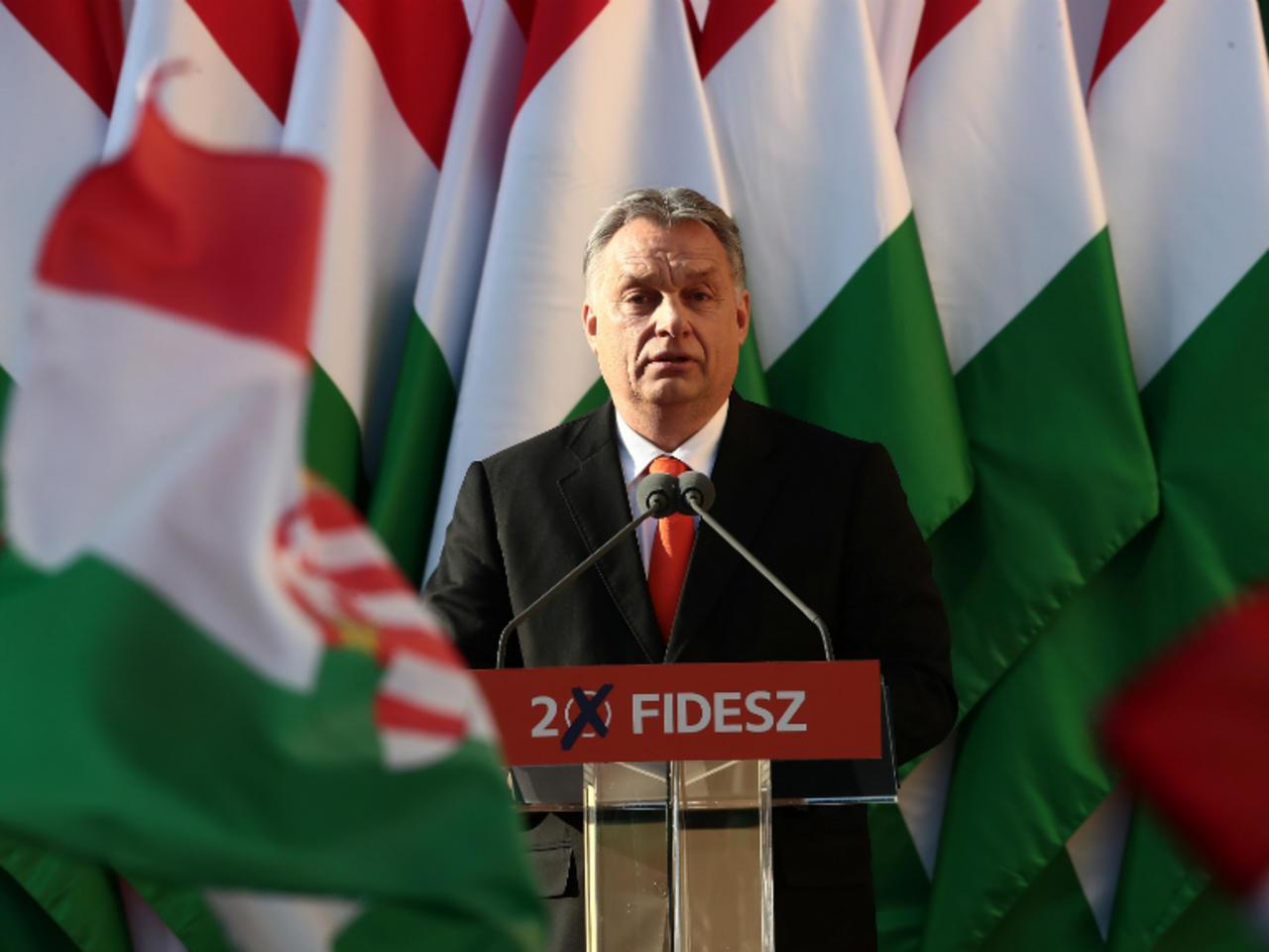 Viktor Orban em discurso com a bandeira da Hungria ao fundo