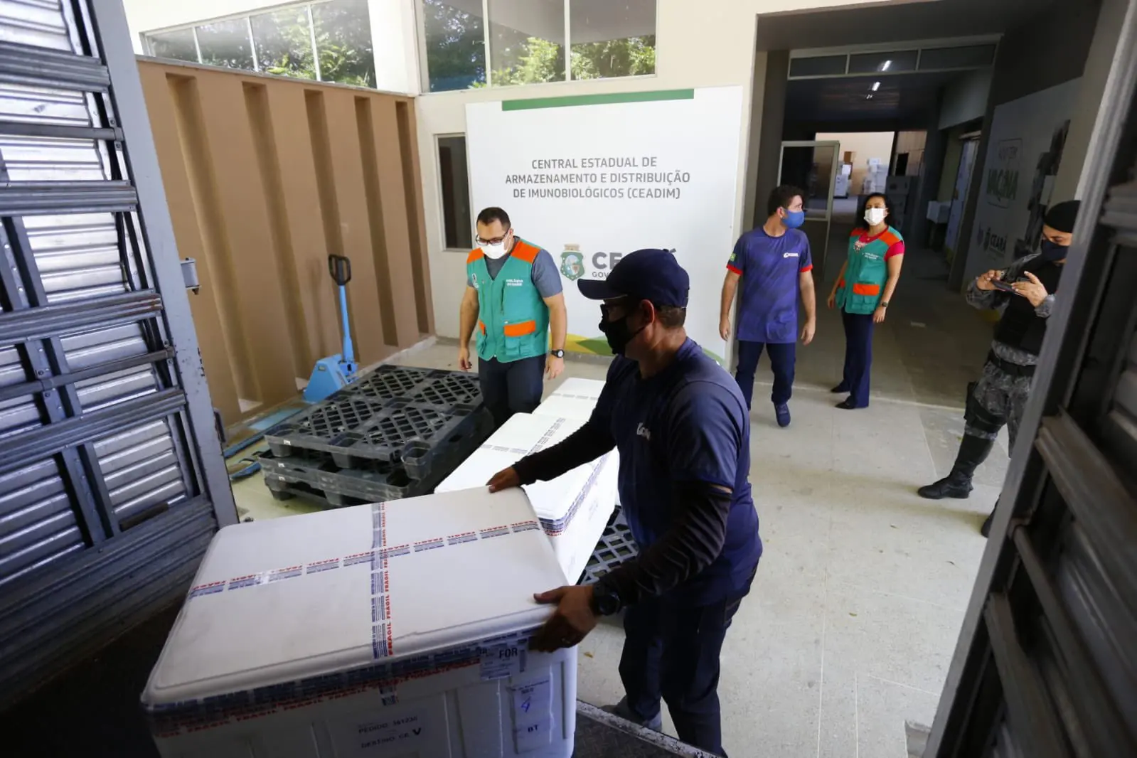 Pessoas distribuindo carga de vacina contra Covid-19