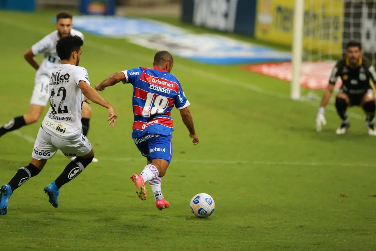 Atleta do Fortaleza disputa bola com jogadores do Santos