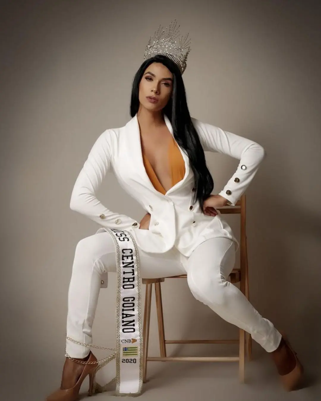 Rayka Vieira usando smoking branco e coroa de miss