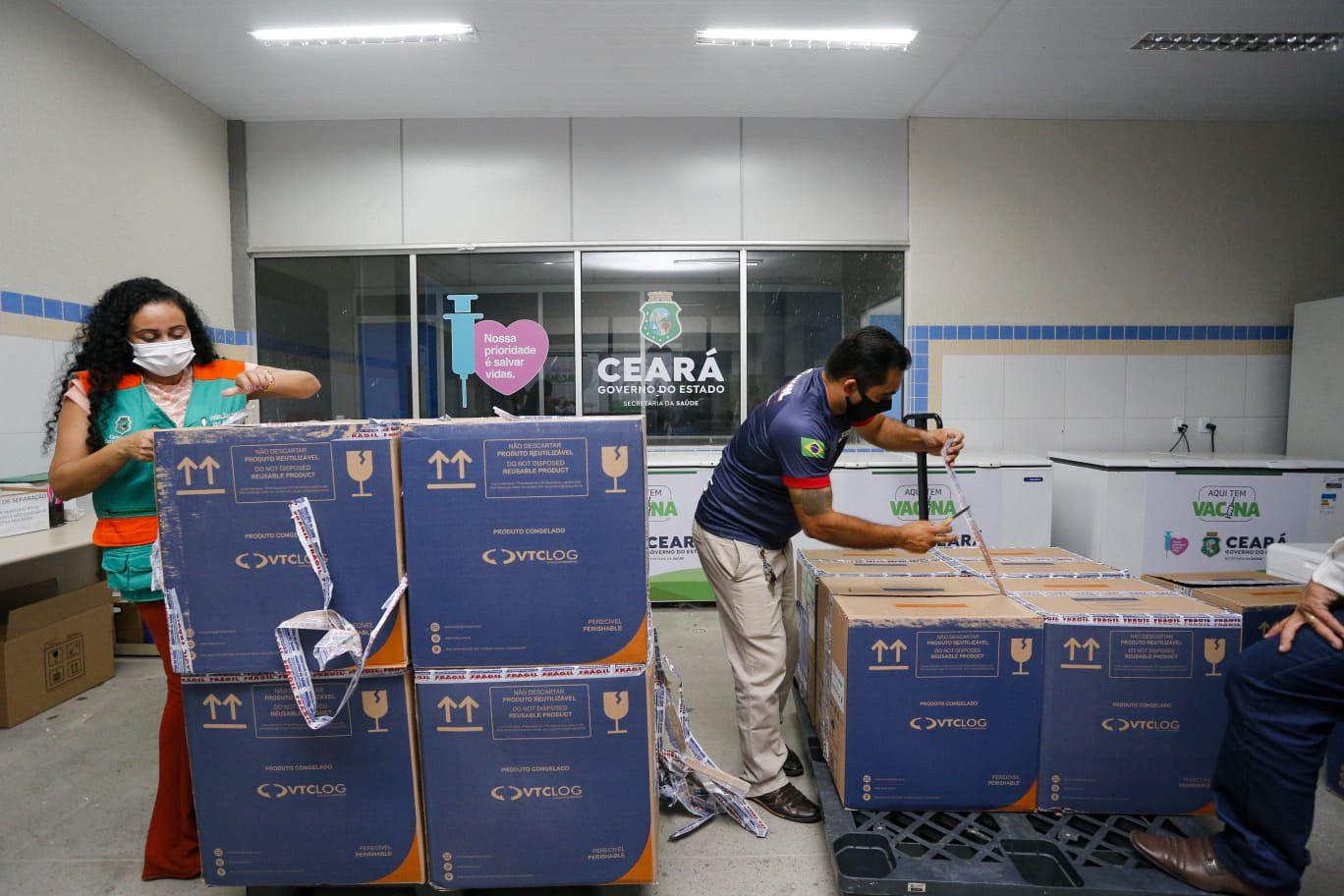 Trabalhadores desembalando caixas com vacinas contra Covid-19