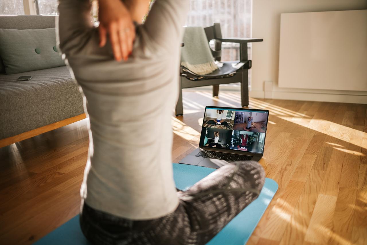pessoa praticando yoga em casa durante aula online