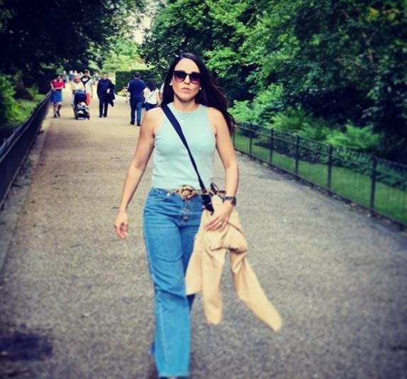 Juliana Lobo de óculos escuro andando em parque em Londres