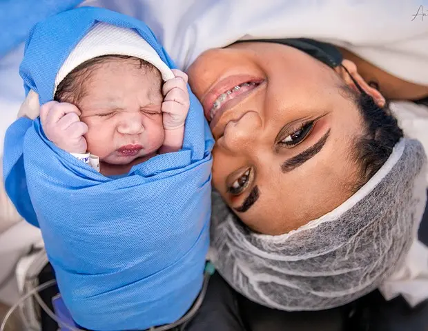 Noah Gabriel enrolado em manta ao lado da mãe Raíza