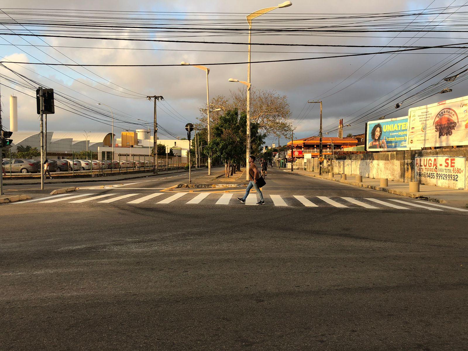 Homem atravessando avenida na faixa de pedestres em Fortaleza, no Ceará