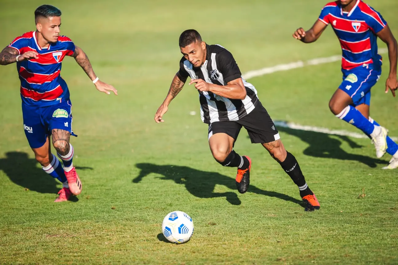 Hélio Borges com a bola é observado por marcadores