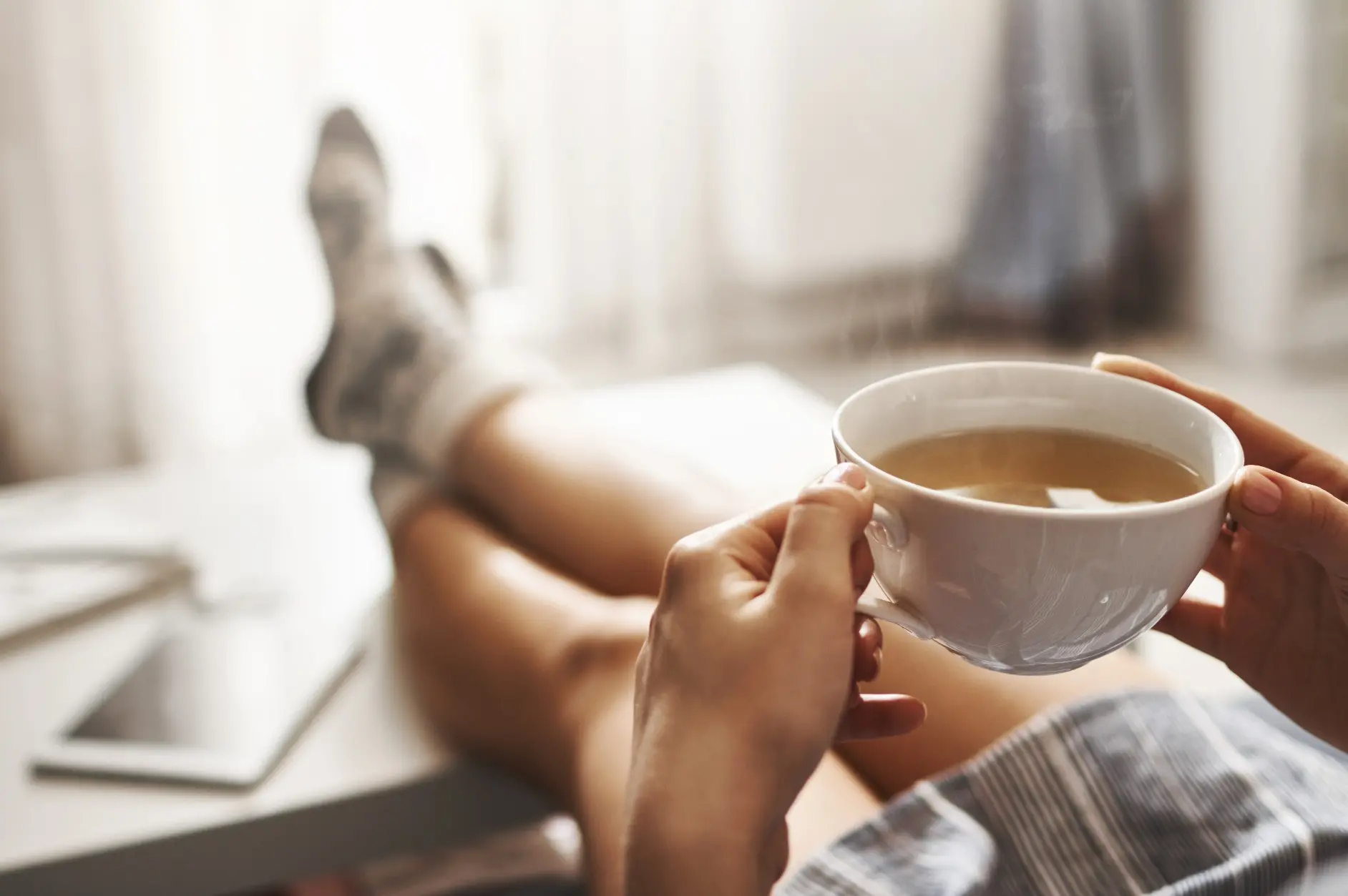Pessoa tomando chá em uma xícara branca