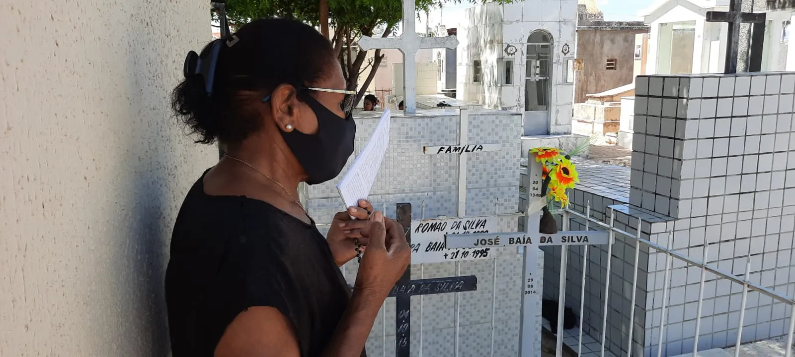 Dona de casa reza o terço em memória dos parentes falecidos