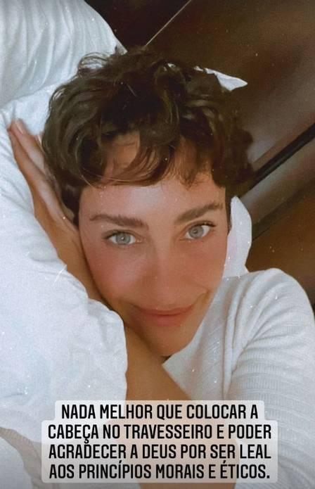 Cynthia Benini deitada sobre travesseiro com legenda escrita sobre foto