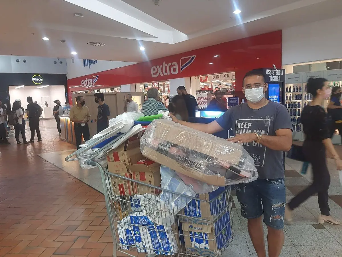 homem com carrinho cheio de compras