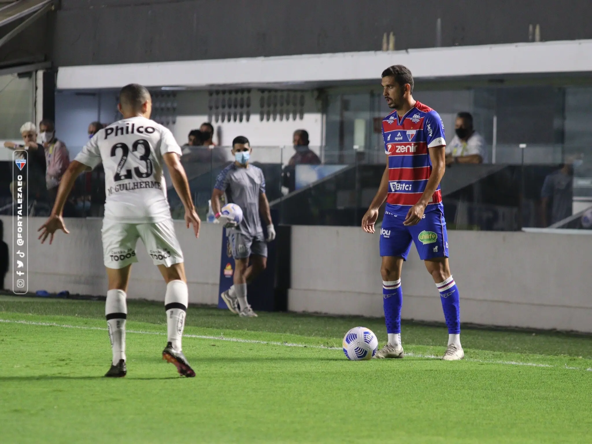 Bruno Melo com a bola dominada é observado por jogador do Santos