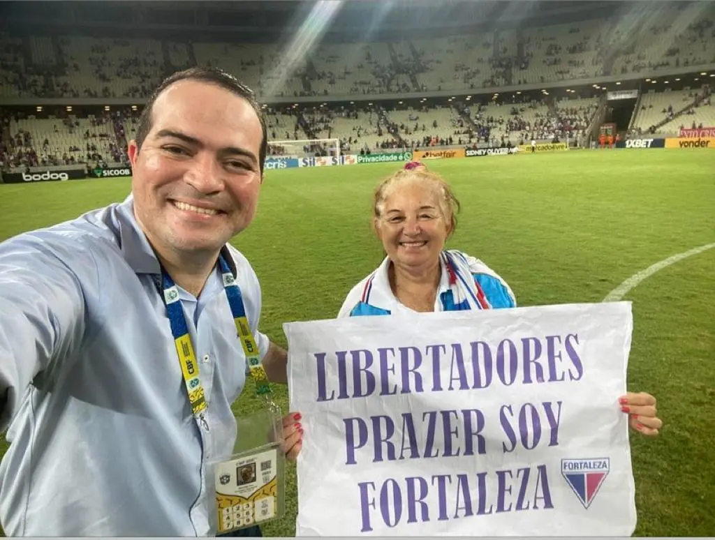 Marcelo Paz e Toinha segurando cartaz de classificação para a Libertadores