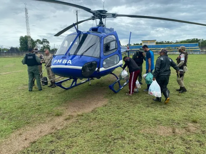 pessoas carregando sacolas embarcam em helicóptero